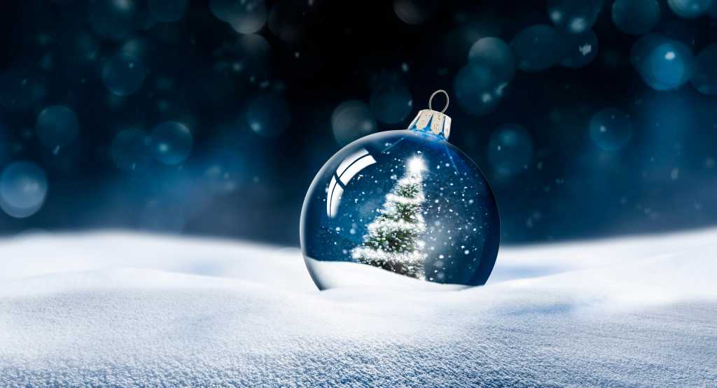 All I want for Christmas is a server-side JavaScript framework Christmas tree snow globe ornament in the snow with a blue night background.