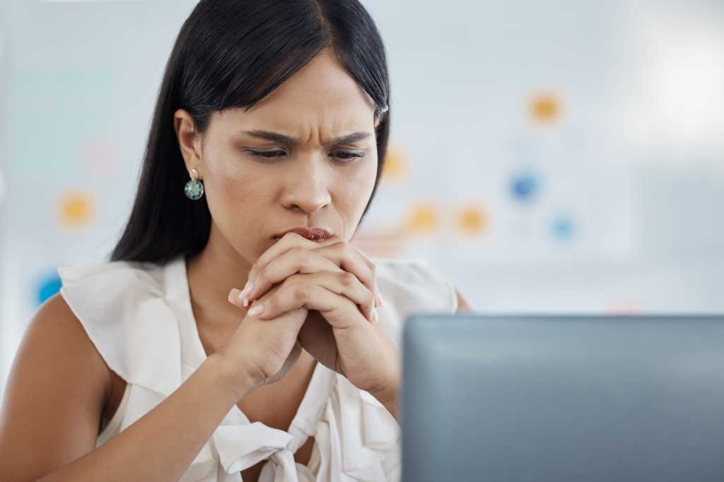 CIOs keep buying tools. Workers keep burning out. Here’s the disconnect Anxiety, stress and business woman on laptop in office, reading email of phishing, 404 or glitch. Thinking, worry and burnout with corporate employee frustrated by loan rejection and startup fail