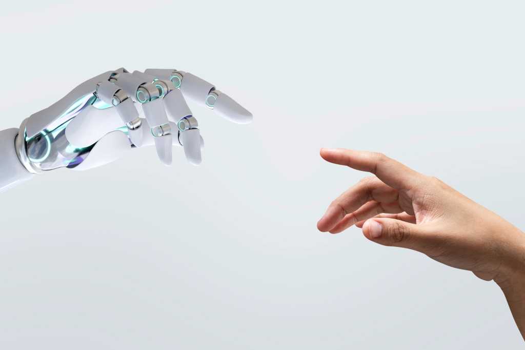 Cuatro recomendaciones para que los CIO salven la brecha de confianza en la IA A futuristic image of a robotic hand reaching out to a human hand, symbolizes future technology. This blend of technology and humanity of the connection between human and robotic artificial intelligence AI interactions.