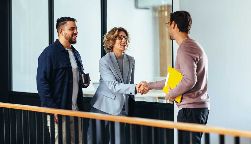 When hiring AI skills, focus on critical thinking Professional woman shaking hands with a new employee in an office. Happy business woman hiring a job candidate. Business people forming a new partnership in a startup.