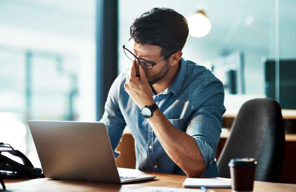 How to stop the AI code generation treadmill Stressed, tired and frustrated business man with headache at night from burnout or making mistake on laptop. Overworked creative entrepreneur failing to meet late office deadline or working overtime
