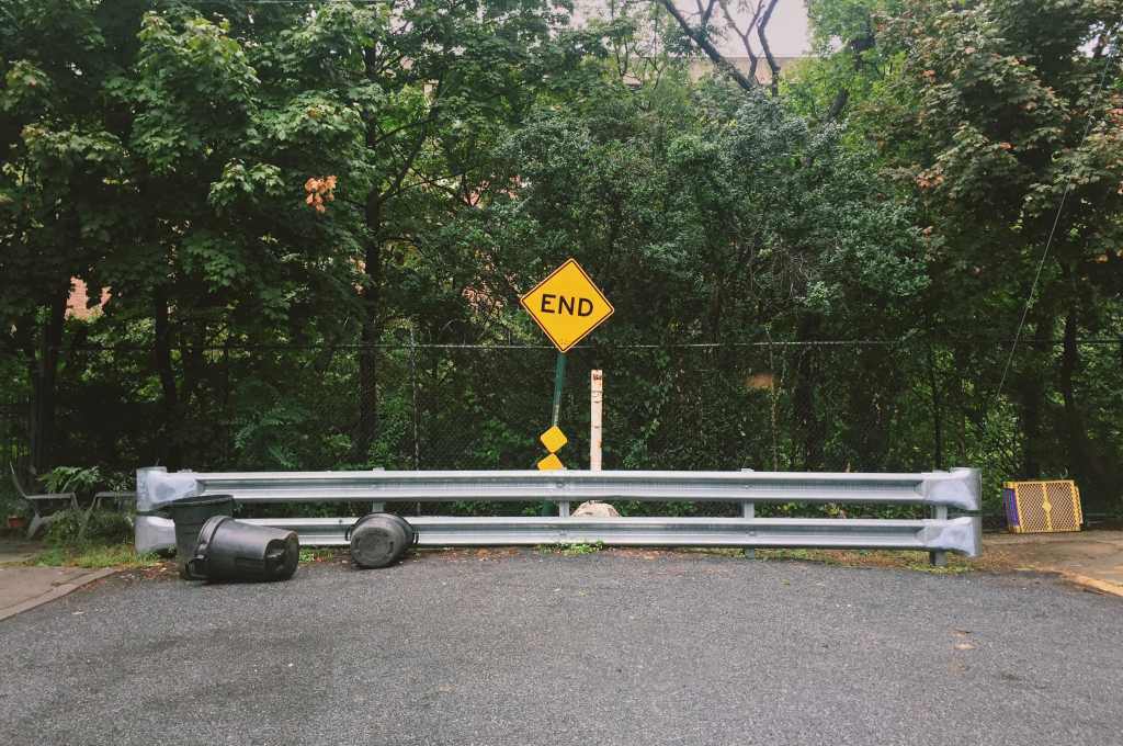 It’s crunch time for Java modernization End of the road with End sign, barrier, tipped garbage cans, chain link fence, and green trees in the background